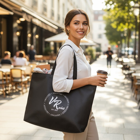  Woman carrying a black VRochét reusable tote bag with a white logo over her shoulder outdoors.